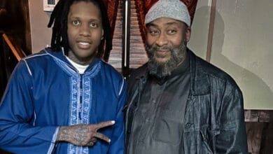 Lil Durk Visits Chicago Mosque to Promote Unity and Respect for Muslim Community - WhatsonRap rapper Lil Durk at a Chicago mosque, surrounded by members of the Muslim community, with a prayer rug in the foreground.